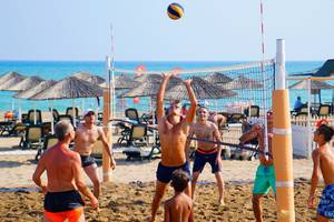 Ein Volleyballspiel am Strand im Baia Lara Hotel mit mehreren Spielern und einem Ball in der Luft.