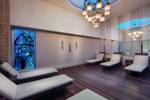 Loungebereich im Baia Lara Hotel mit weißen Liegen und einem blauen Kunstfenster.