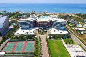 Luftaufnahme des Baia Lara Hotels mit Tennisplätzen, Meer und Wasserrutschen.