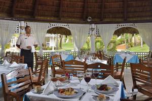 Innenansicht des Restaurants im Sol Palmeras Hotel mit einem Kellner, der an einem Tisch steht.