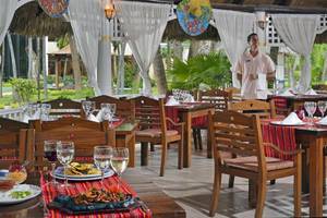 Restaurant des Sol Palmeras Hotels mit gedeckten Tischen und einem Kellner, der lächelt.