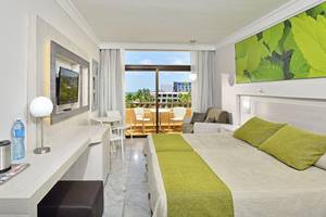 Hotelzimmer im Sol Palmeras mit zwei Betten, Schreibtisch, Fernseher und Balkon mit Meerblick.