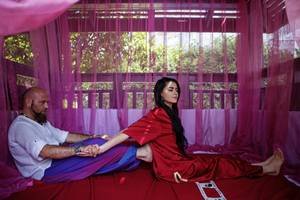 Mann und Frau im roten Bett im Hotel Liberty Hotels Lara