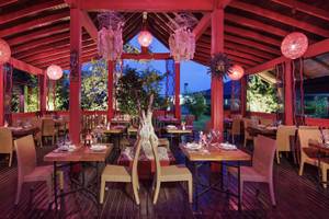 Innenansicht des Restaurants im Liberty Hotels Lara mit roten Säulen und Holzboden.