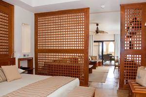 Schlafzimmer im Grand Waterworld Makadi Hotel mit Holzelementen und modernen Möbeln.