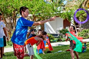 Kinder spielen mit Hula-Hoop-Ringen im Garten des Civitel Creta Beach Hotels.