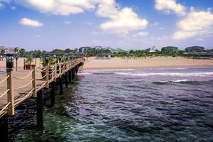 Das VONRESORT Golden Coast verfügt über einen Pier am Strand mit Solarleuchten und Blumentöpfen.