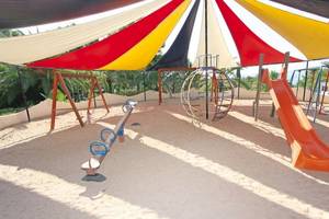 Kinderspielplatz im Marble Stella Maris Ibiza Hotel, geschützt durch ein farbenfrohes Zelt.