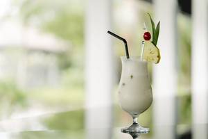 Cocktailglas mit Strohhalm und Ananasdekoration im Noku Maldives Hotel.