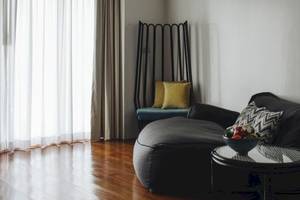 Wohnzimmer des Noku Maldives Hotels mit einem großen grauen Sitzsack und einem Tisch mit Obst.