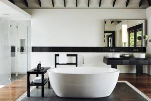 Luxus Badezimmer im Noku Maldives mit Badewanne, Waschbecken und Glasdusche