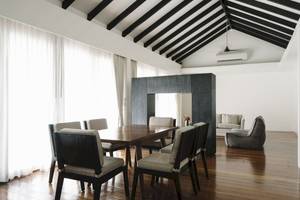 Innenansicht des Speisezimmers im Noku Maldives Hotel mit Holzboden, weißen Wänden und Möbeln.