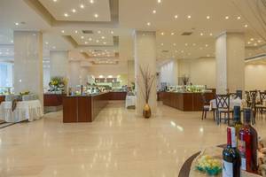 Frühstücksbuffet im Kresten Palace Hotel mit Tisch und Stühlen, gedeckten Tischen und Getränken.