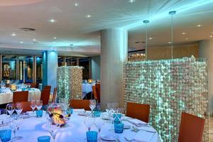 Innenbereich des Barcelo Illetas Albatros Hotels mit blauen Beleuchtung und Tisch-Arrangements.