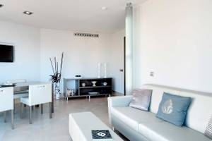 Wohnbereich des Barcelo Illetas Albatros Hotel mit weißem Esstisch, Stühlen und Sofa.