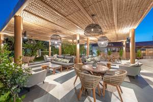 Außenbereich des Ikaros Beach Luxury Resort & Spa mit beleuchteten Möbeln und Pflanzen