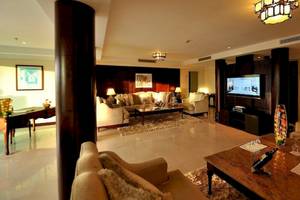 Wohnbereich des Sofitel Agadir Royal Bay Resort mit Möbeln, Fernseher und Lampen.
