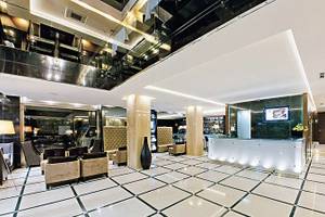 Empfangshalle des Turim AV Liberdade Hotels mit weißer und schwarzer Marmorfliesenboden und moderner Einrichtung.