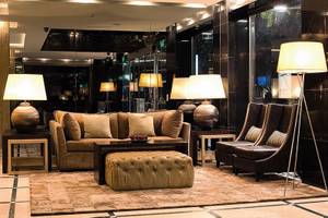 Hotellobby mit einem großen Sofa, Lampen und einem Teppich auf dem Boden.