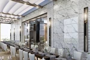Innenansicht des Restaurants im Belad Bont Resort mit Marmorwänden und langen Tischen.