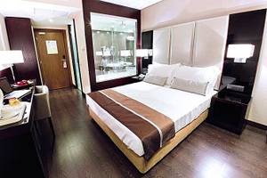 Ein modernes Hotelzimmer im Turim AV Liberdade Hotel mit einem Doppelbett, Schreibtisch, Laptop, und Badezimmerspiegel.