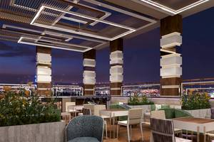 Abendbeleuchtung der Dachterrasse im Belad Bont Resort mit Tischen, Stühlen und Pflanzen
