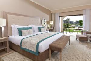 Hotelzimmer im Steigenberger Alcazar mit gepolstertem Kopfteil, großen Bett und offenem Balkon.