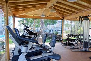 Fitnessstudio im Servatur Waikiki Hotel mit Cardiogeräten und Hanteln.