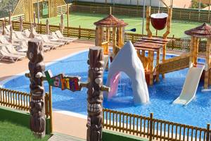 Außenansicht des Wasserparks im Servatur Waikiki Hotel mit Rutschen und Wasserspielgeräten.