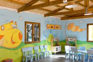 Kinderzimmer im Servatur Waikiki Hotel mit farbenfrohen Wandmalereien und Spielmöbeln.