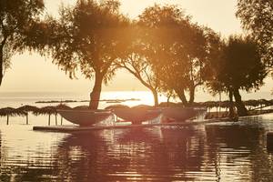 Sonnenuntergang am Pool des Grecotel Casa Marron Hotels mit Wasserfontaenen und Meersicht