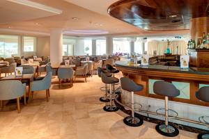 Innenbereich der Bar im Hipotels Hipocampo Playa Hotel mit vielen Tischen und Stühlen.