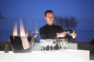 Ein Kellner schenkt Champagner in eine Schale bei Hipotels Hipocampo Playa.