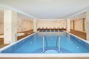 Schwimmbecken im Hipotels Hipocampo Playa Hotel mit weißen Wänden und Holzboden