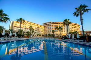 Außenansicht des Fame Residence Lara & Spa Hotels mit großem Swimmingpool und Sonnenliegen