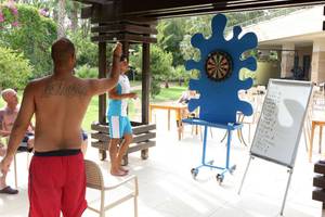 Hotelgäste spielen Dart in einer Außenlounge des Fame Residence Lara & Spa.