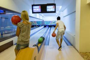 Mann und Frau im Fame Residence Lara & Spa Bowling spielen