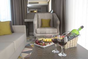 Wohnzimmer mit Tisch, Sofa und Stuhl im Fame Residence Lara & Spa Hotel.