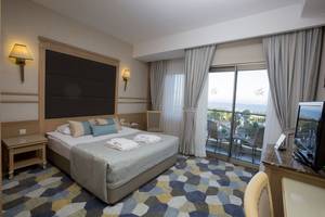 Hotelzimmer mit Meerblick im Fame Residence Lara & Spa mit einem Bett, zwei Nachttischen, einem Fernseher, einem Balkon und Blick auf den Ozean.