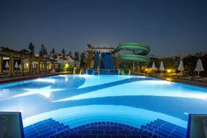 Nachtansicht des Swimmingpools im Fame Residence Lara & Spa Hotel mit Wasserrutschen und Sternendesign.