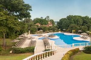 Luftaufnahme des Poolbereichs des Occidental Papagayo Resorts mit Sonnenliegen und Sonnenschirmen.