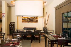 Innenansicht des Restaurants im Occidental Papagayo Hotel mit geräumigen Tischen, Stühlen und einem großen Kronleuchter.
