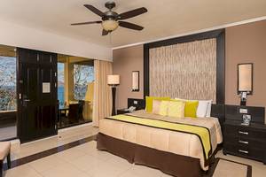 Hotelzimmer im Occidental Papagayo mit Meerblick, inklusive Doppelbett, Deckenventilator und großer Terrasse.