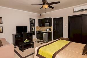 Suite im Occidental Papagayo Hotel mit Fernseher, Couch, Tisch, Klimaanlage und Küche