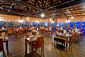 Innenansicht des KoruMar Hotel De Luxe Restaurant mit holzboden, tischen und stühlen