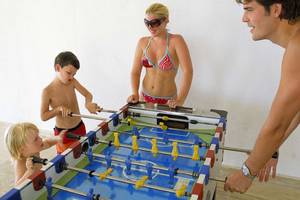 Eine Familie spielt Tischfußball im KoruMar Hotel De Luxe