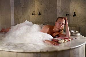 Frau genießt eine entspannende Zeit in einer Bubble Badewanne im KoruMarr Hotel