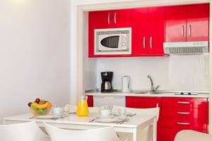 Kueche des H10 Suites Lanzarote Gardens Hotels mit roten Schranken und weisser Tischgarnitur.