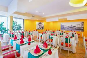 Innenansicht des Restaurants im Iberostar Playa Gaviotas Hotel mit gedeckten Tischen und gelben Wänden.