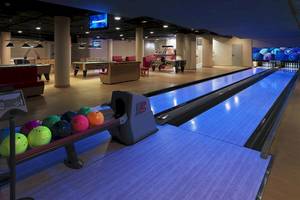 Bowlinghalle im Hotel mit Bowlingbahnen, Billardtischen und Fernsehern.